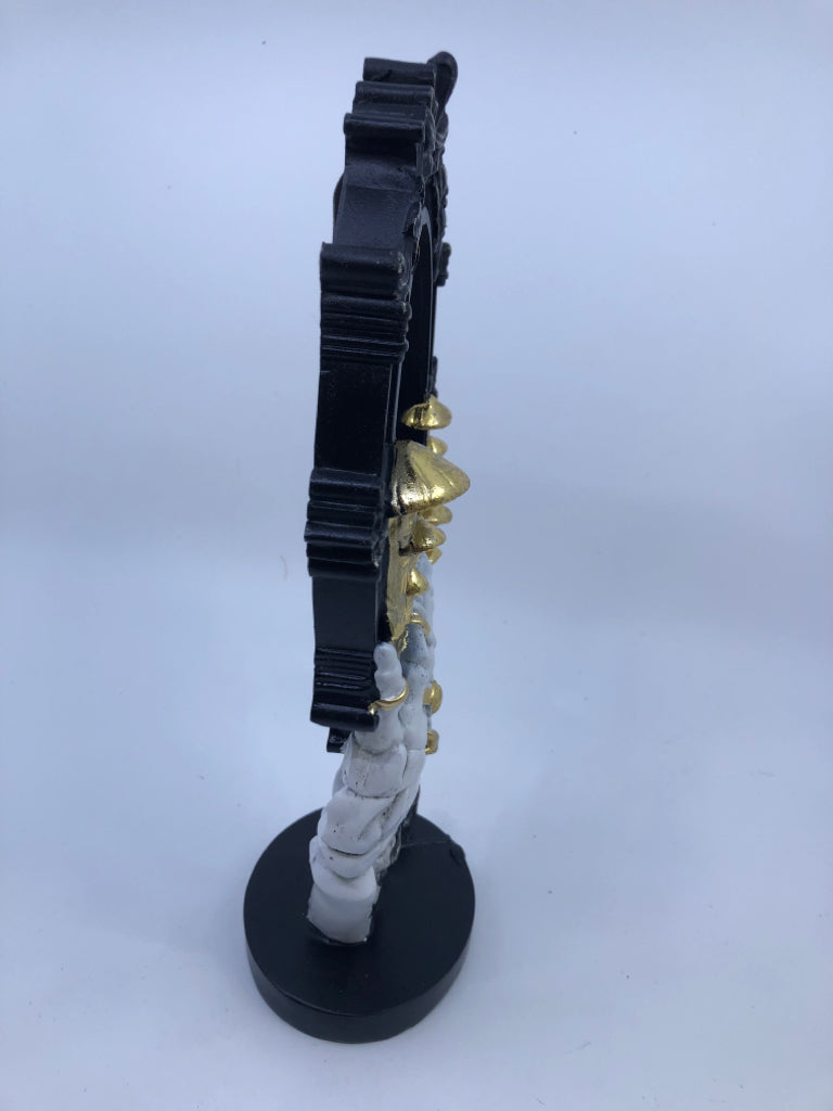 RESIN SKELTON HAND HOLDING BLACK MIRROR W/ GOLD MUSHROOMS.