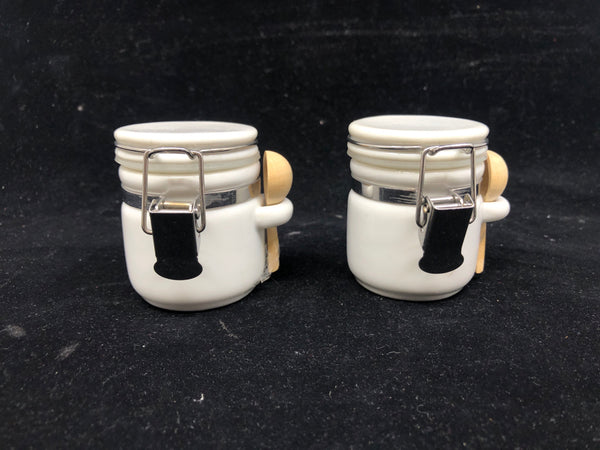 2 SMALL WHITE CANISTERS W WOOD SPOONS.