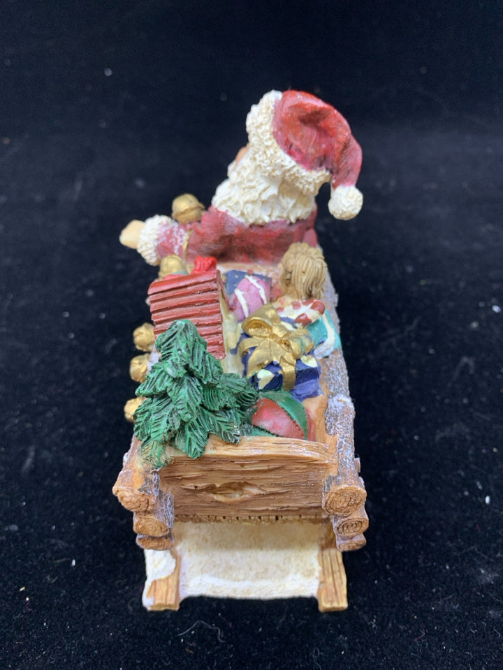 SANTA SITTING ON SLEIGH W TOYS.