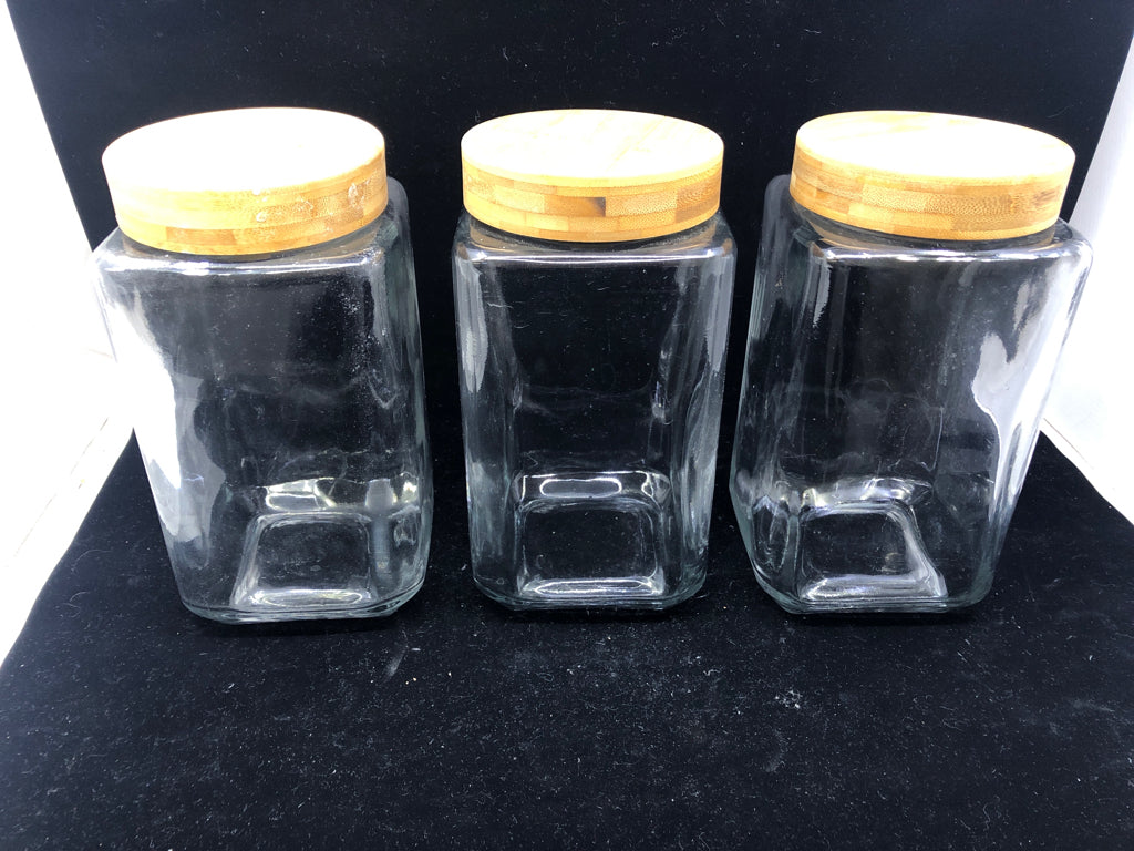 3 GLASS SQUARE CANISTERS W/ WOOD TOPS.