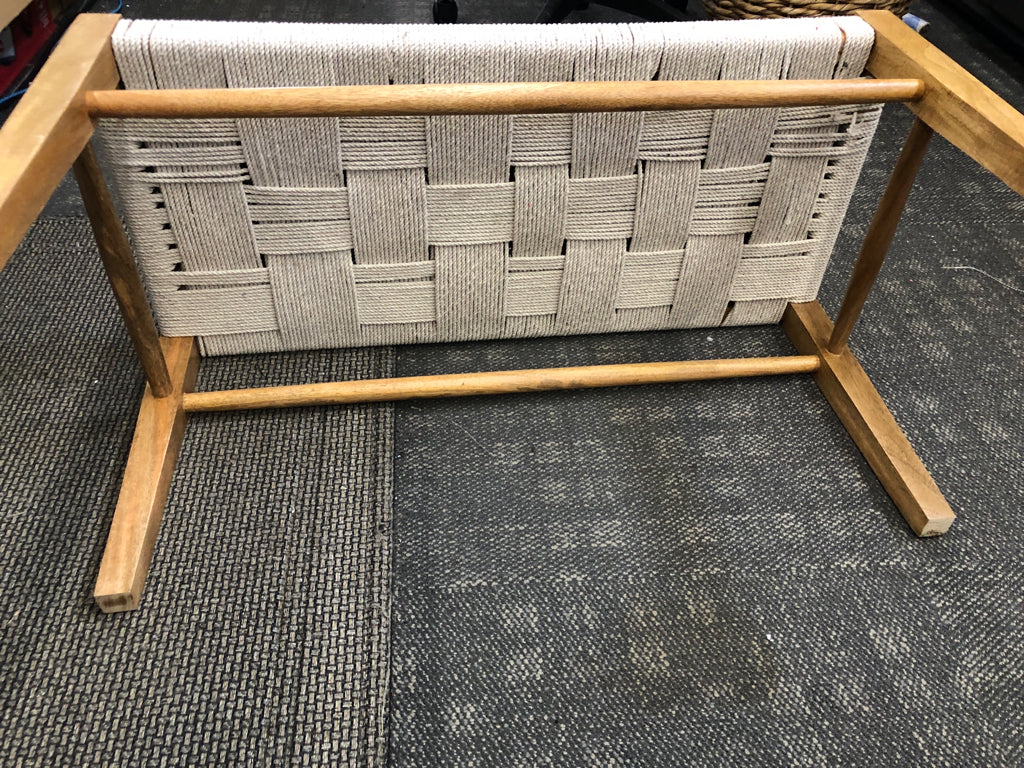WOOD BENCH WITH GRAY ROPE SEATING.