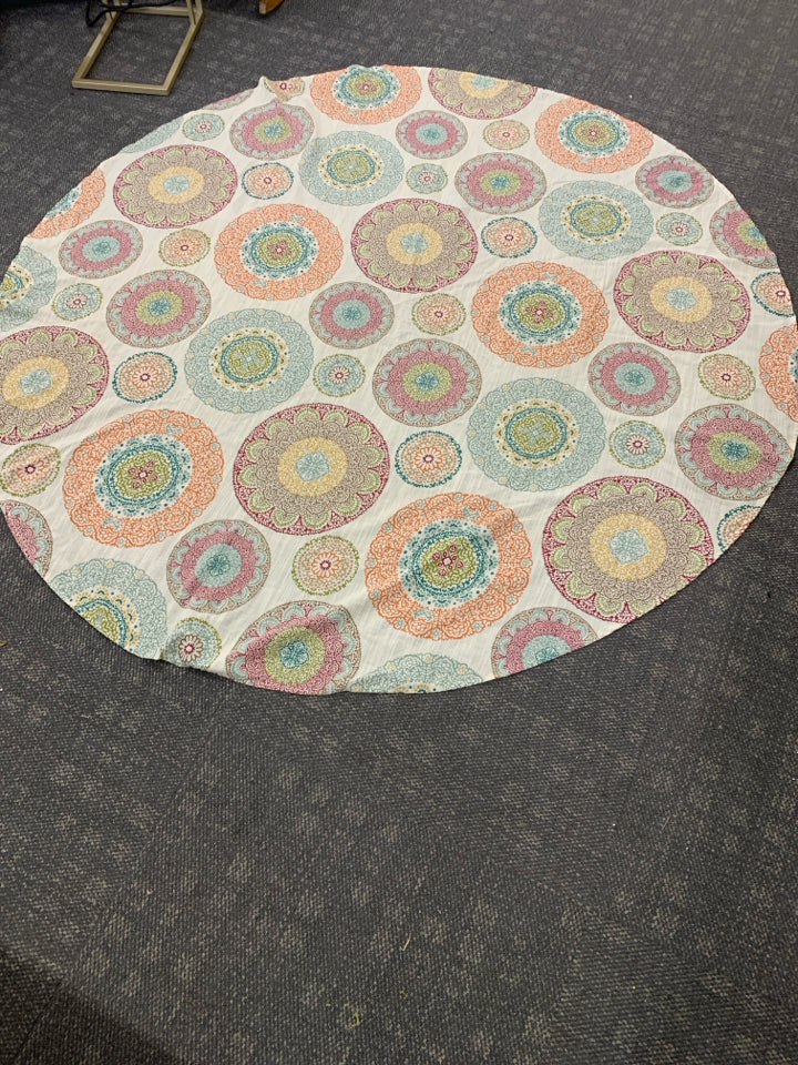 CREAM CIRCLE TABLECLOTH W/ COLORFUL MEDALLION PATTERN.