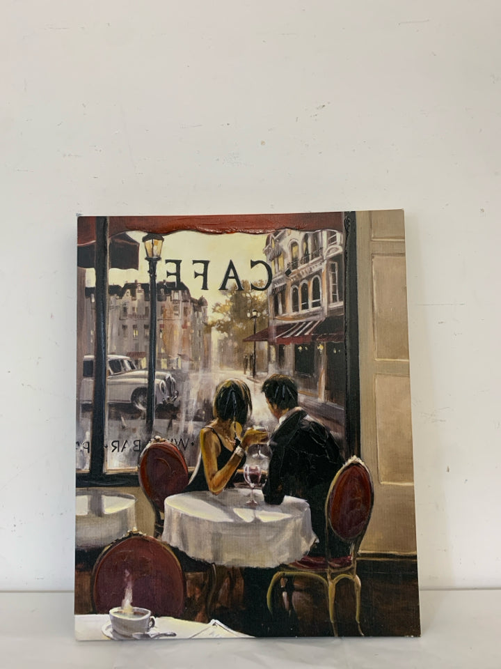 COUPLE SITTING IN A CAFE LOOKING OUT THE WINDOW W/ WINE CANVAS.