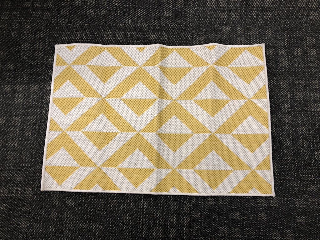 TAN/YELLOW PATTERNED RUG.