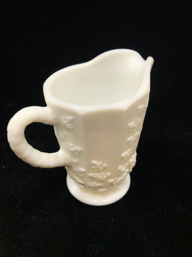 VTG MILK GLASS PITCHER W/EMBOSSED FLORAL DESIGNS.