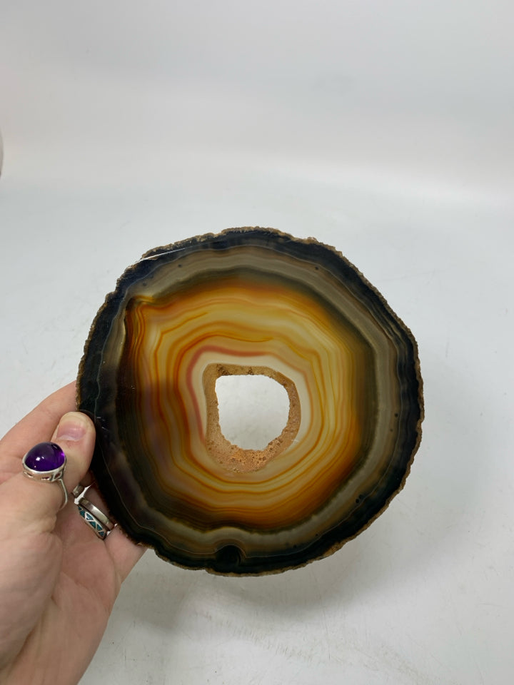 BROWN/ORANGE CRYSTAL SLICE W/ HOLE IN CENTER TRIVET.