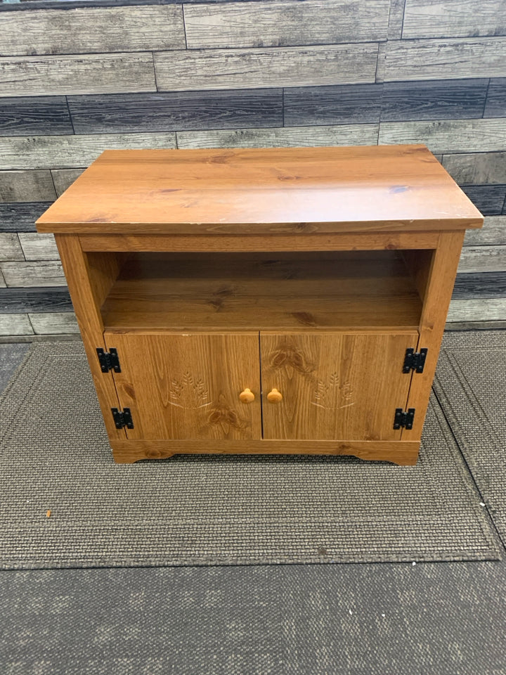 BLONDE WOOD TV STAND W WHEAT ON DOORS.