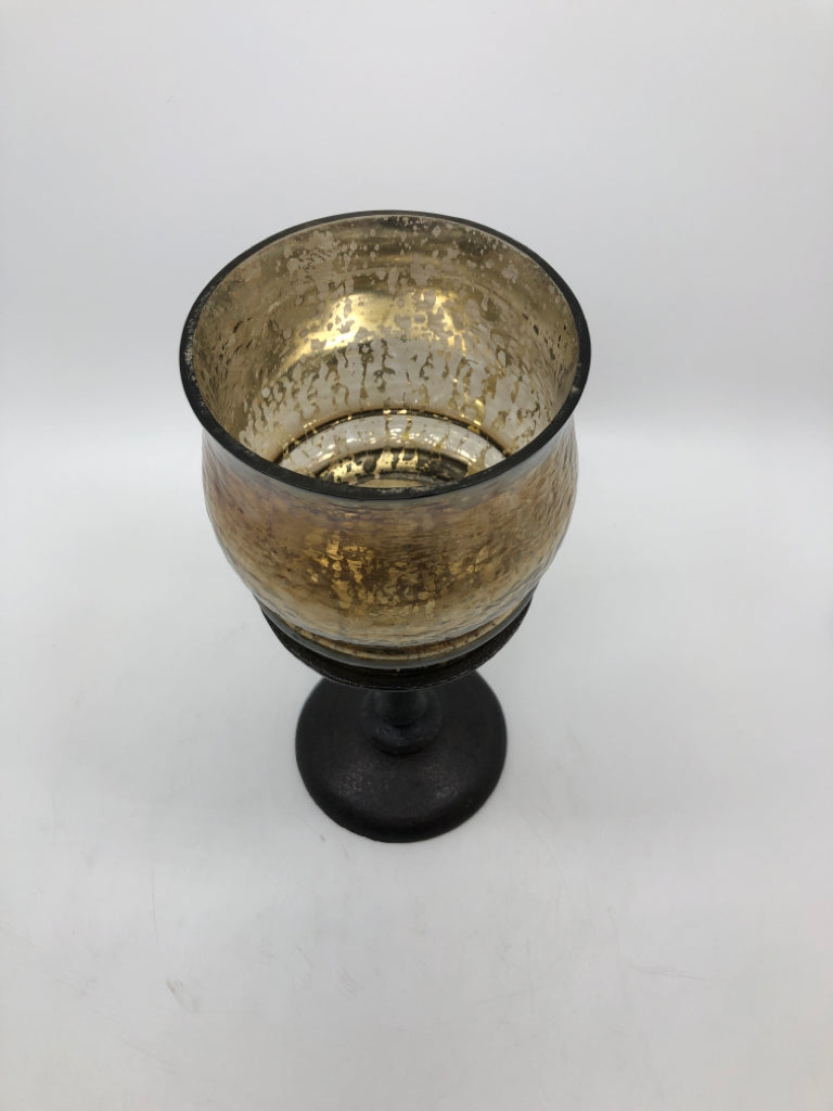 GOLD MERCURY GLASS CANDLE HOLDER ON BROWN METAL BASE.