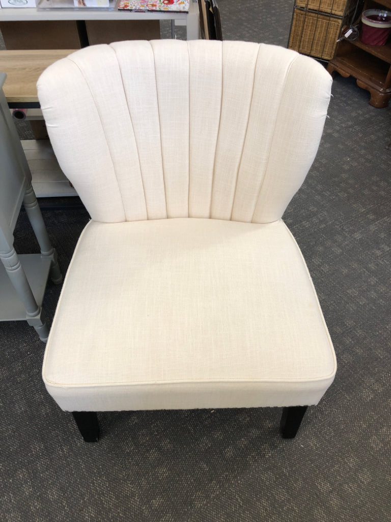 WHITE ACCENT CHAIR STUDDED BOTTOM W/ BLACK LEGS.
