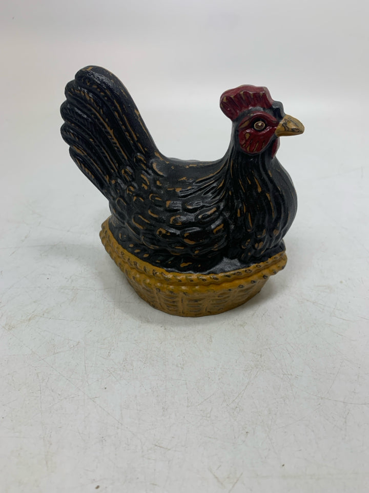 BLACK DISTRESSED HEN SITTING IN NEST.