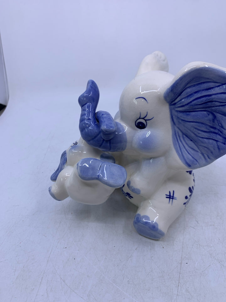 BLUE/WHITE SITTING ELEPHANT W/ BABY HANGING FROM TRUNK COIN BANK.