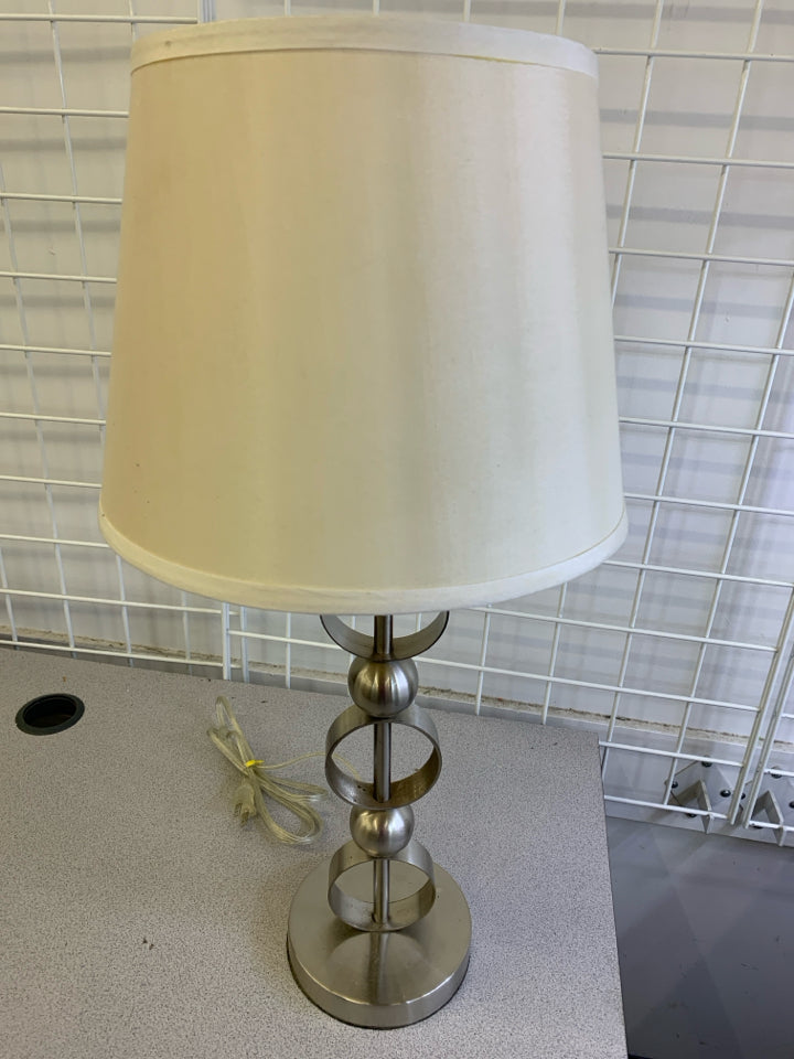 SILVER CIRCLE BASE LAMP W CREAM SHADE.