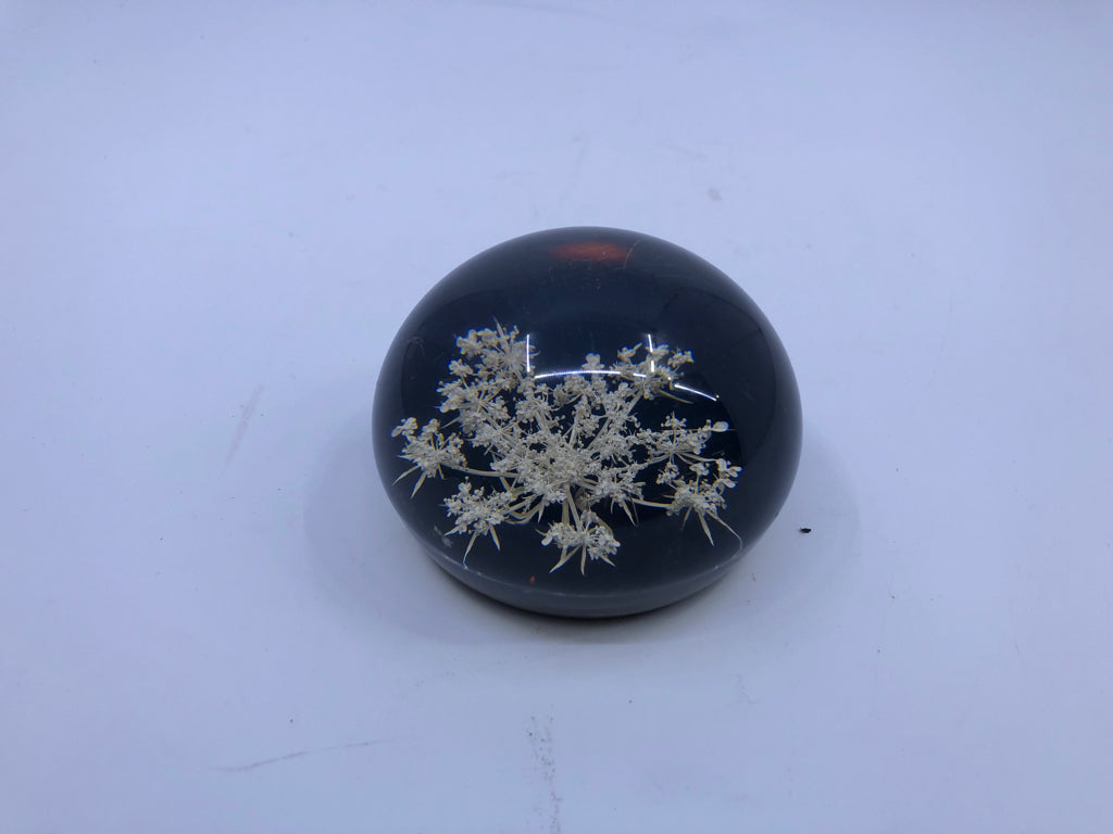 RESIN PAPER WEIGHT BLACK BOTTOM W/ WHITE FLOWERS.