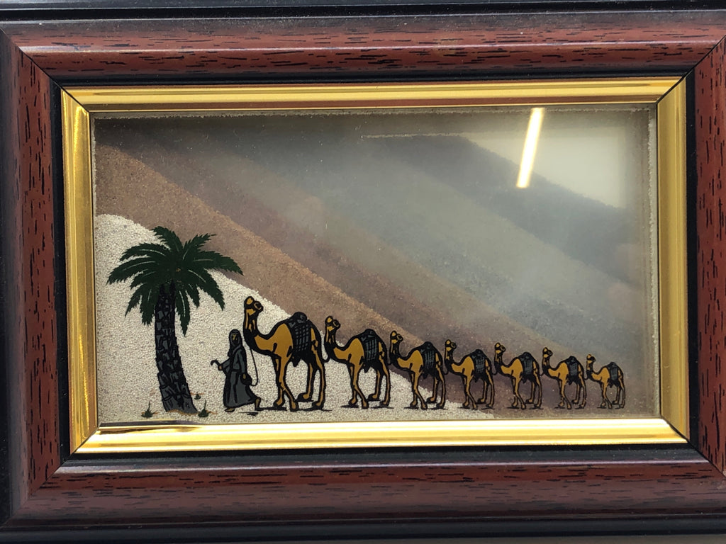 MAN LEADING CAMELS IN FRAME WALL ART.