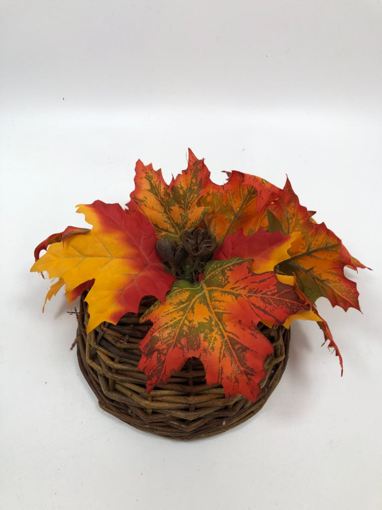 ORANGE LEAVES IN BROWN WICKER HANGING BASKET.