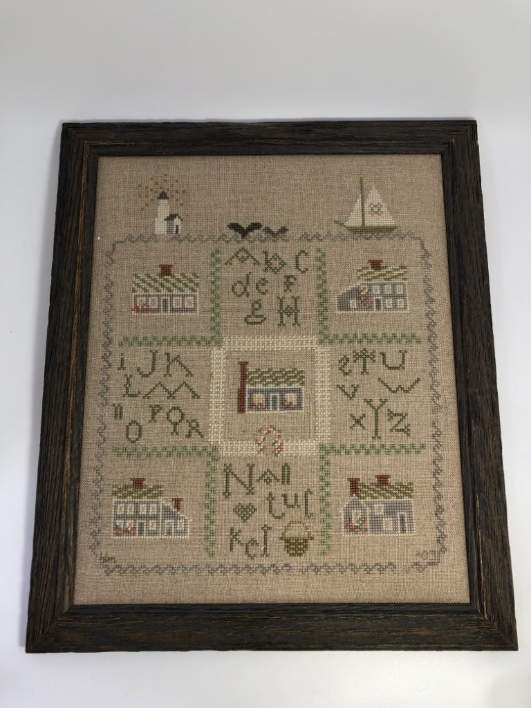 STITCHED LIGHTHOUSE ALPHABET FRAMED CROSS-STITCH IN DISTRESSED BROWN FRAME.