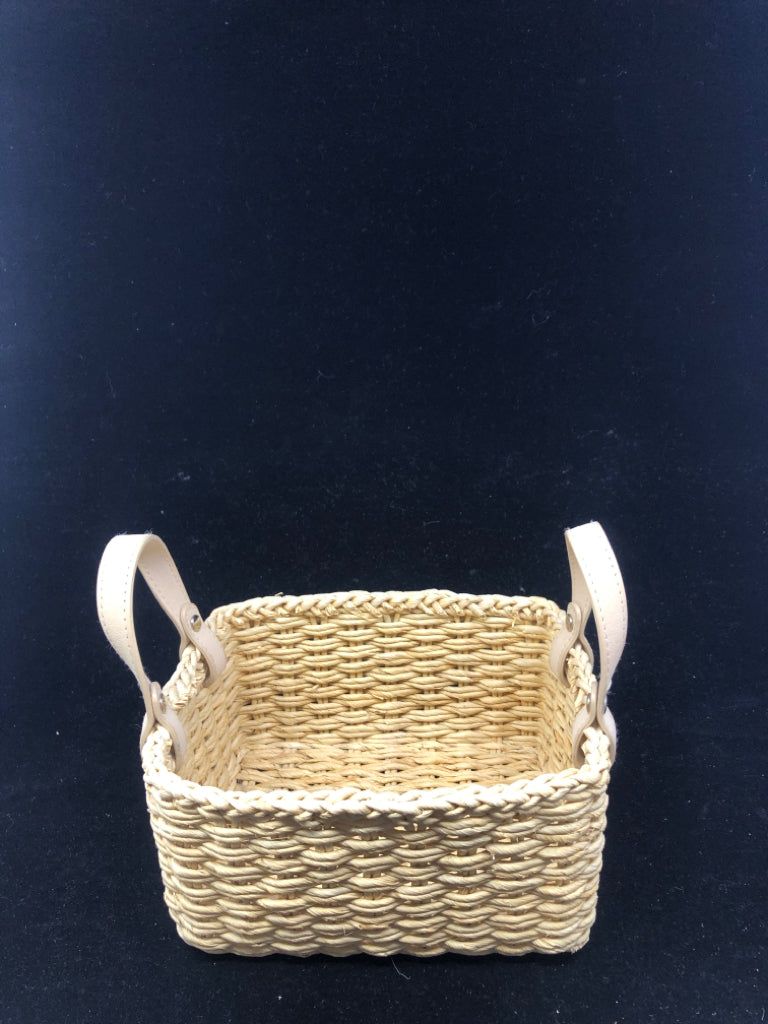 SMALL FLEXIBLE WOVEN BASKET W/ BEIGE FAUX LEATHER HANDLES.