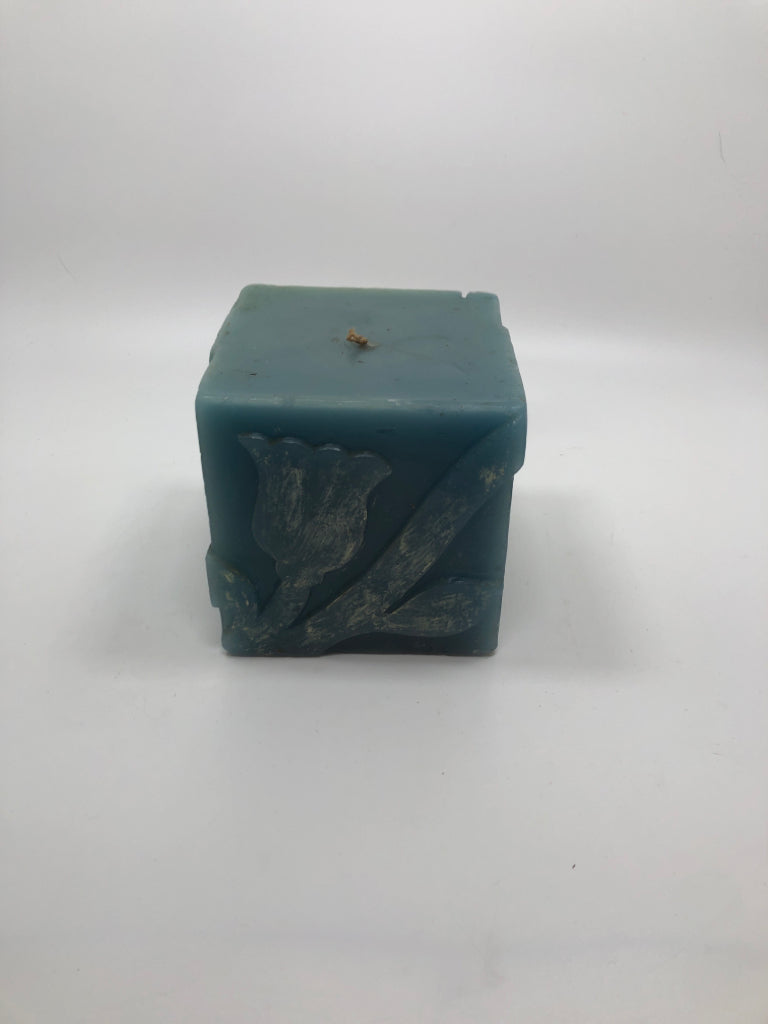 POTPOURRI DESIGNS SQUARE BLUE CANDLE W/FLORAL ETCHINGS.