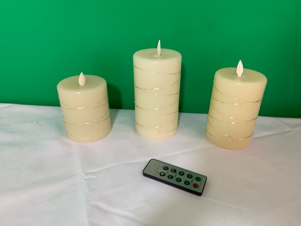 3 WHITE WITH GOLD BATTERY OPERATED CANDLES WITH REMOTE.
