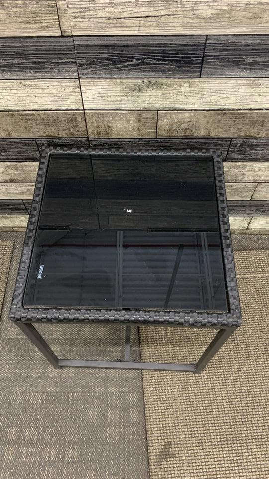 BLACK METAL OUTDOOR SIDE TABLE W/WOVEN EDGE AND TEMPERED GLASS TOP.