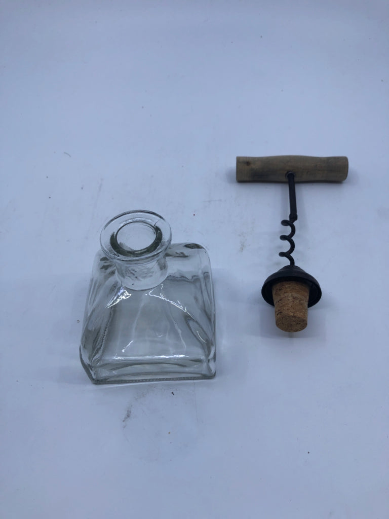 SMALL GLASS EMPTY BOTTLE VASE W/ METAL WINE OPENER TOP.