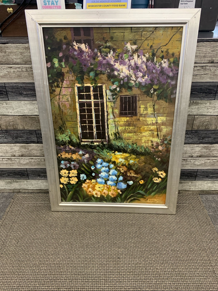 LARGE FLOWER GARDEN IN FRONT OF BUILDING PRINT IN SILVER FRAME.