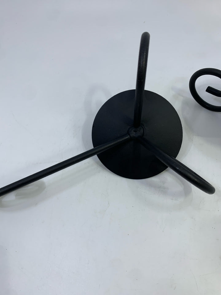 2 BLACK METAL SCROLL CANDLESTICK HOLDERS.