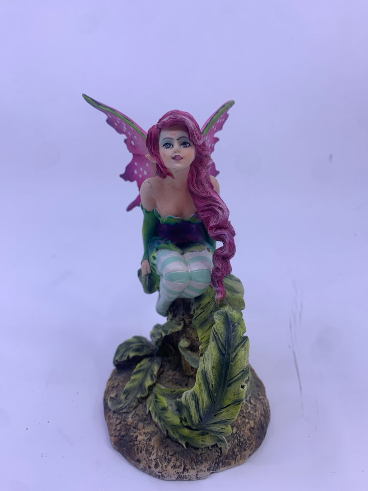 RESIN FAIRY SITTING ON A STUMP W/ PURPLE WINGS.