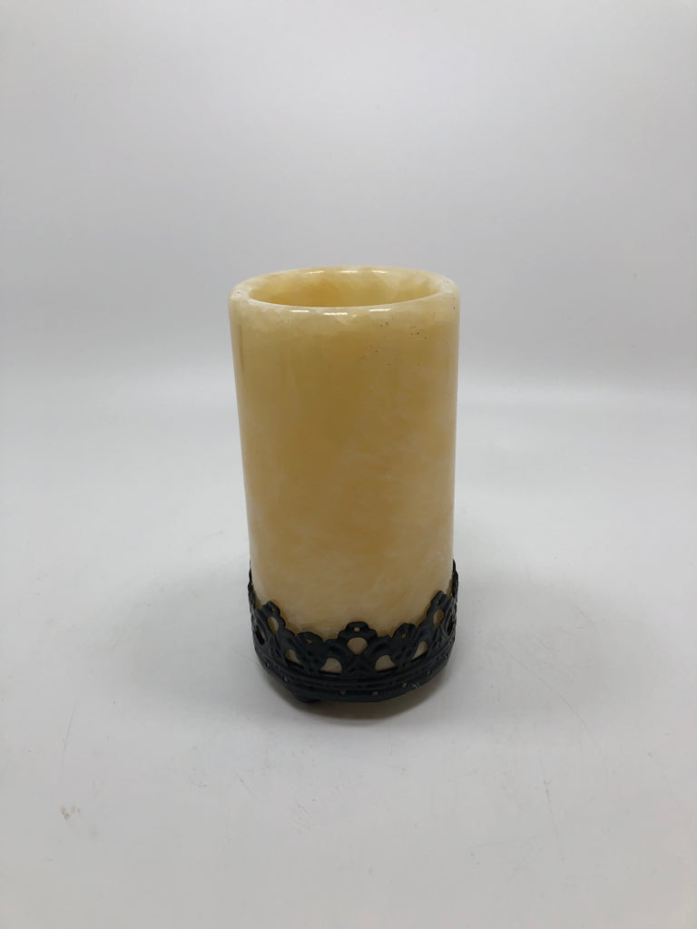 CREAM RESIN TEA LIGHT HOLDER ON BLACK METAL BASE.