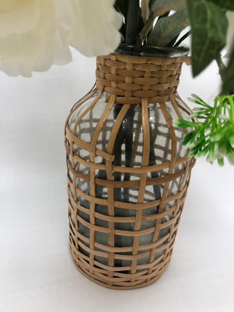 WHITE FLORALS IN COVERED WEAVE GLASS VASE.