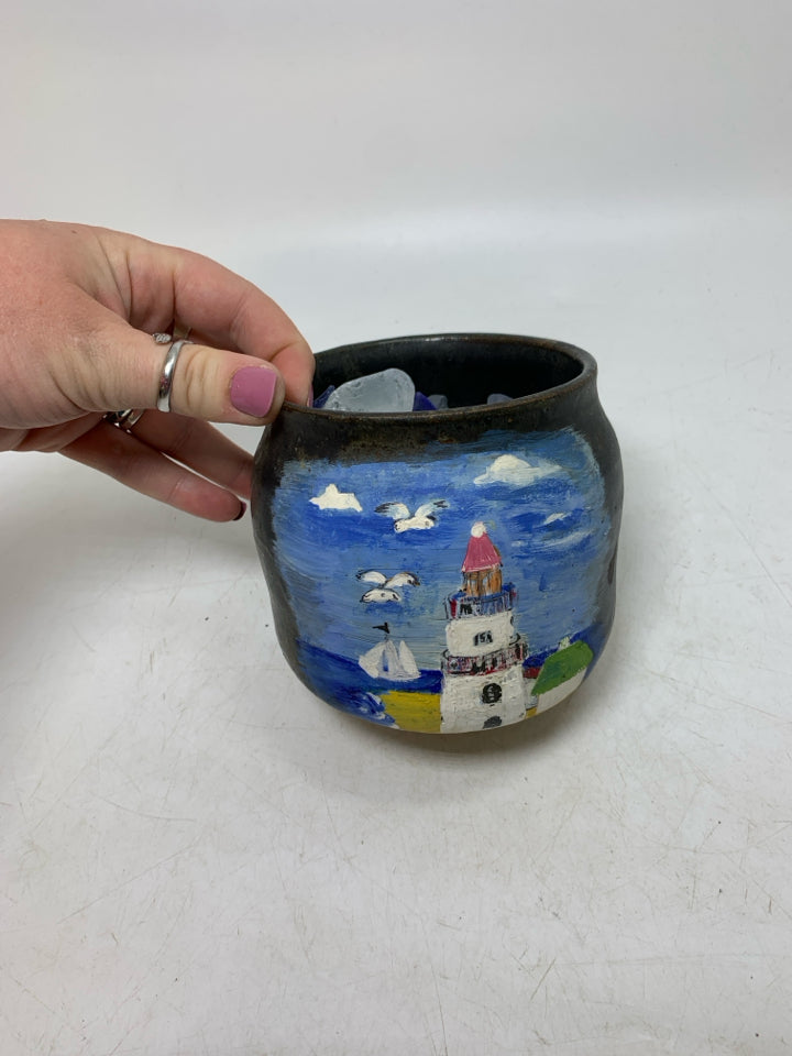DARK PLANTER W/ PAINTED LIGHT HOUSE FILLER W/ SEA GLASS IN BAG.