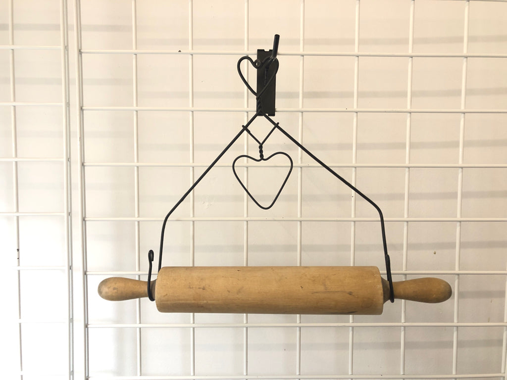 PRIMITIVE ROLLING PIN IN METAL WIRE HOLDER.