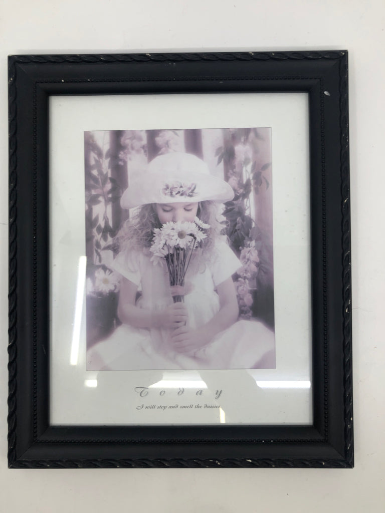 LITTLE GIRL SMELLING FLOWERS IN BLACK FRAME.