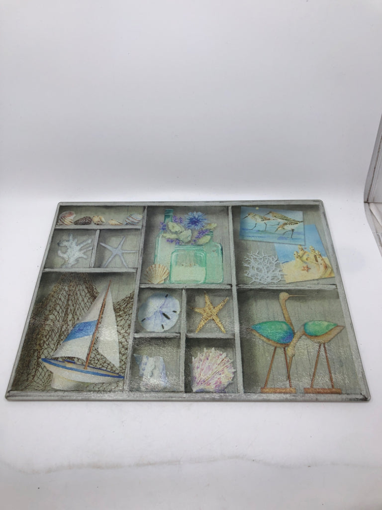 SEASHELL ON GREY SHELVES GLASS CUTTING BOARD.
