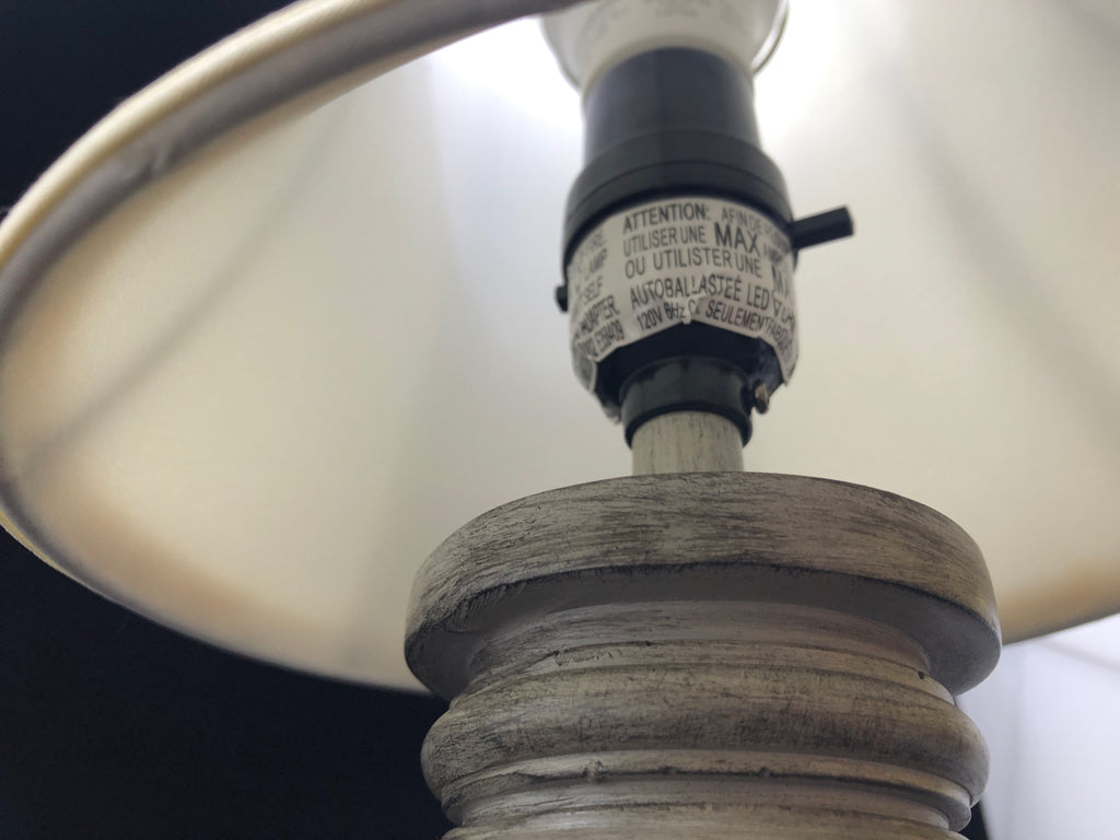 GREY WOOD BASE TABLE LAMP W/CREAM SHADE.