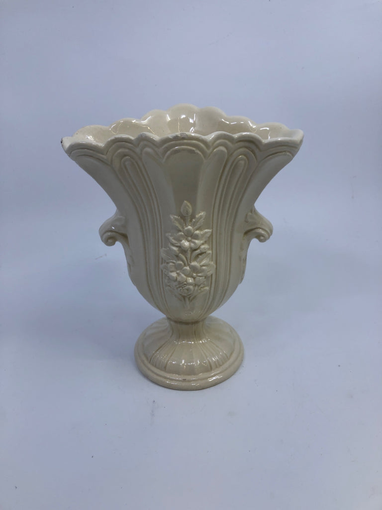 CREAM CERAMIC FOOTED VASE W/FLOWER DETAIL.