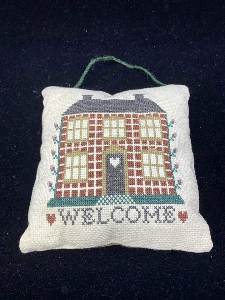 EMBROIDERED WELCOME PILLOW.