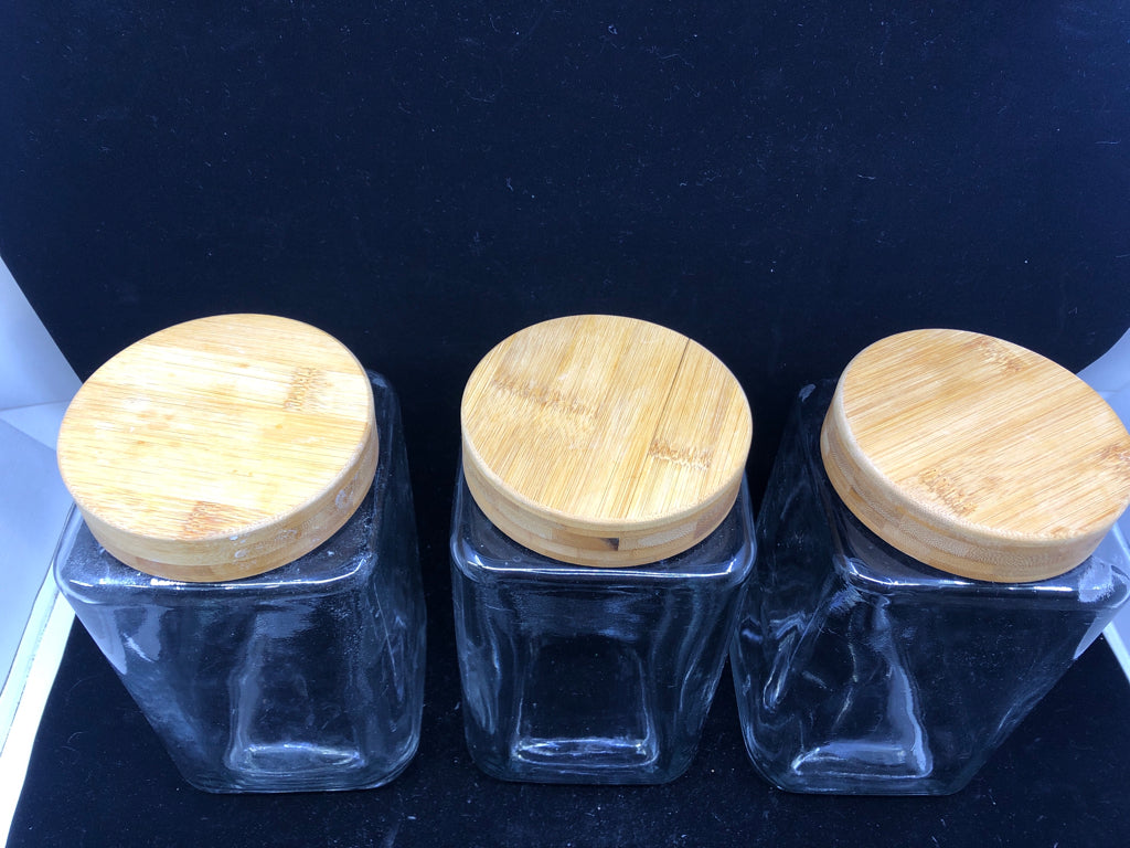 3 GLASS SQUARE CANISTERS W/ WOOD TOPS.