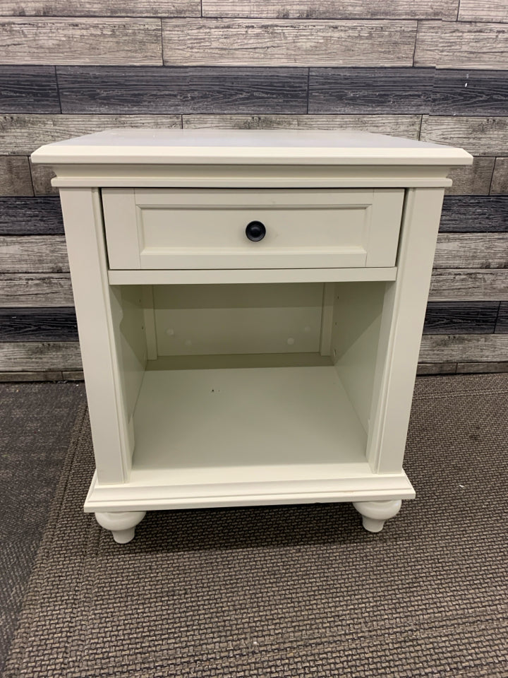 WHITE NIGHT STAND W/ DRAWER BLACK HARDWARE.