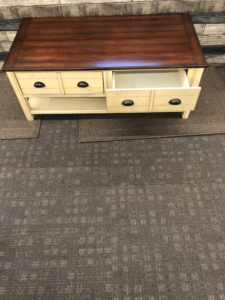 CREAM AND DARK WOOD TOP DISTRESSED COFFEE TABLE.