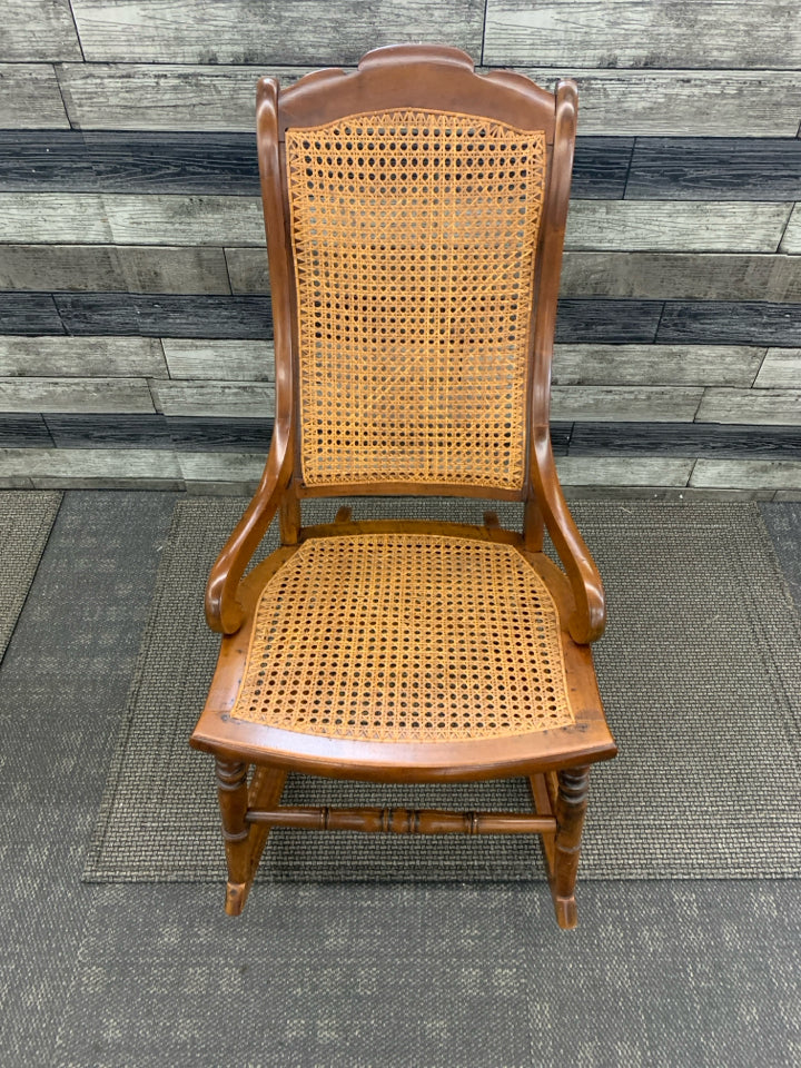 VINTAGE DARK BROWN CANE SEAT ROCKER.