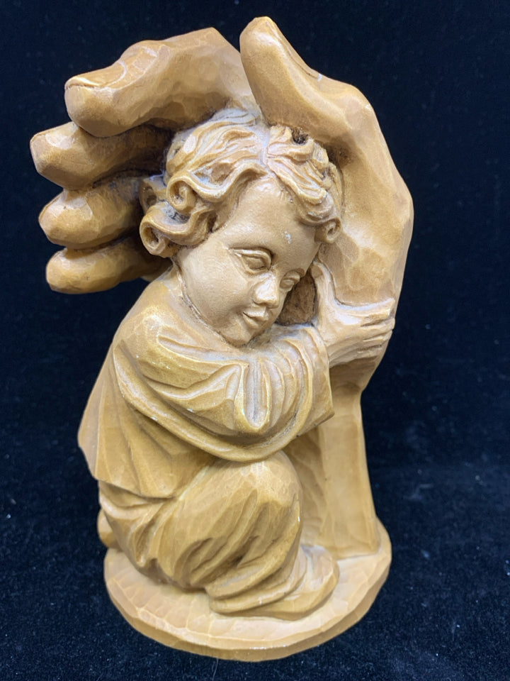RESIN CARVED HAND HOLDING BABY.