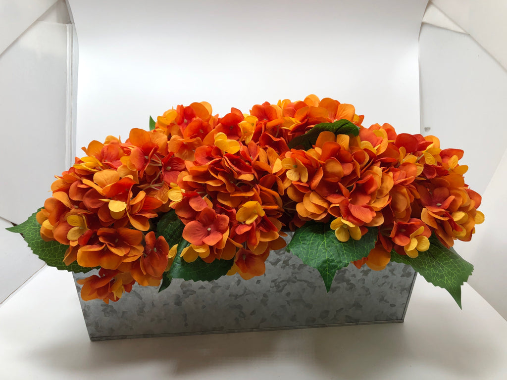 FAUX ORANGE HYDRANGEAS IN TIN PLANTER.