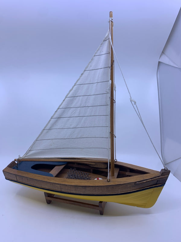 YELLOW AND WOOD SAILBOAT ON STAND.