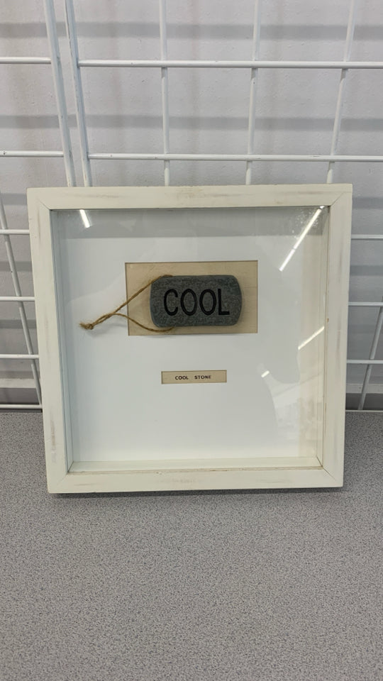 COOL STONE IN WHITE WOOD FRAME.