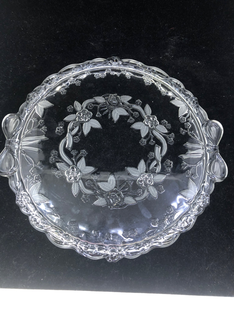 CLEAR GLASS CAKE PLATE W/ ETCHED FLOWERS/EMBOSSED BOW HANDLES.