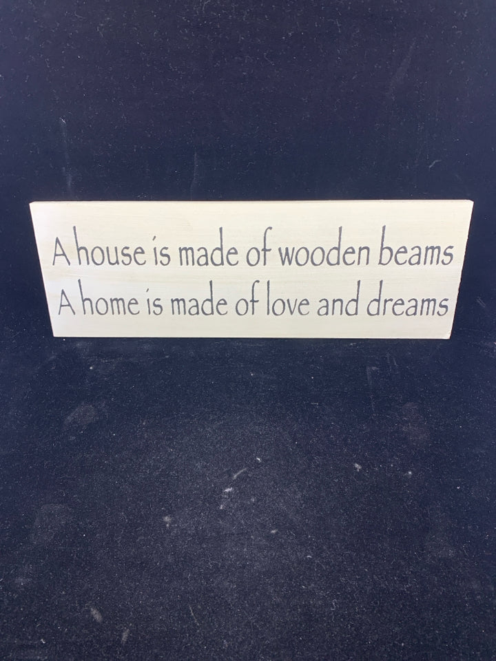 A HOUSE IS WHITE WOOD WALL ART W/ BLACK LETTERS.