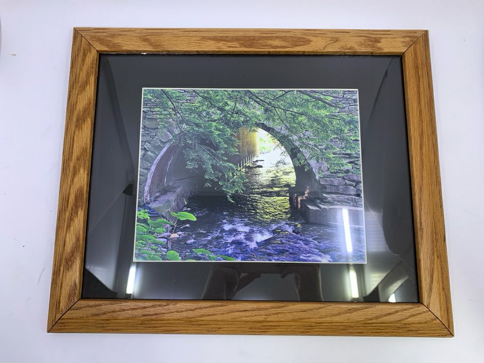 STREAM UNDER BRIDGE PHOTO IN WOOD FRAME.