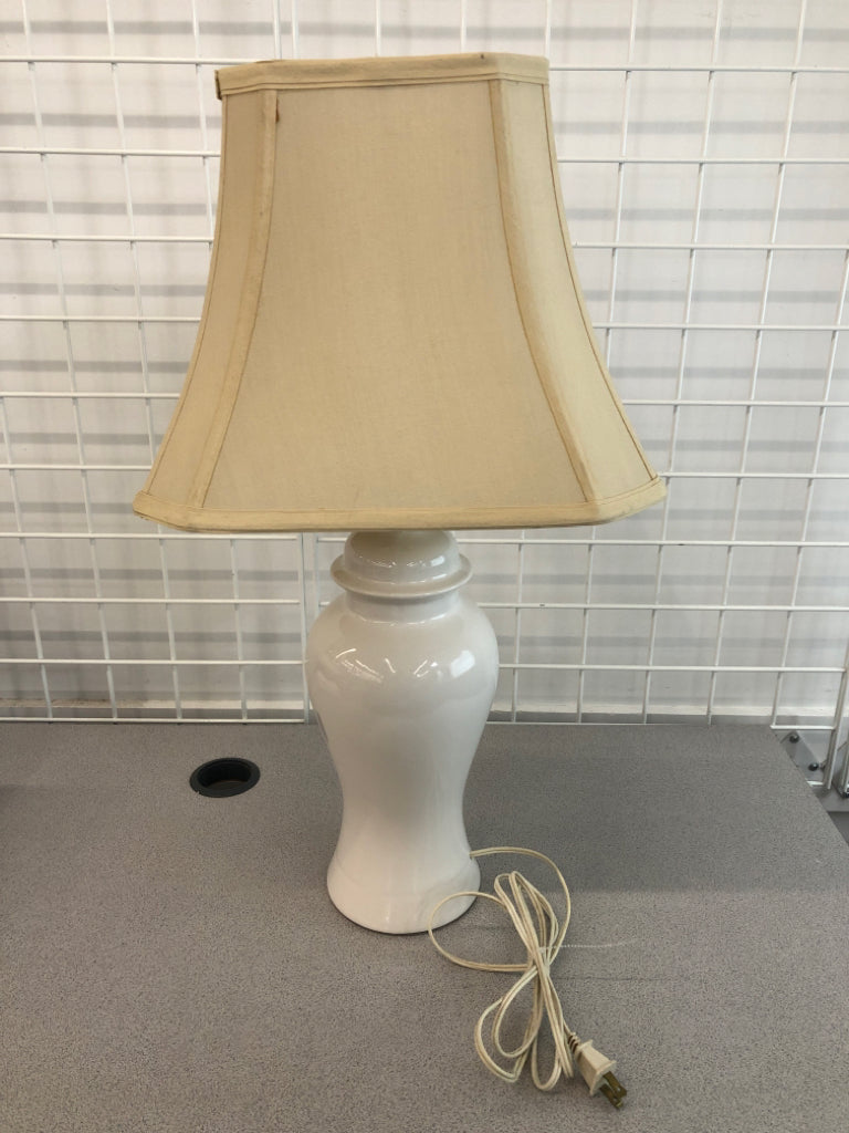 WHITE HOURGLASS SHAPED LAMP W/CREAM SHADE.