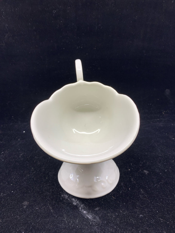 CREAM FOOTED FLORAL SCROLL EMBOSSED TILTED GRAVY BOAT.